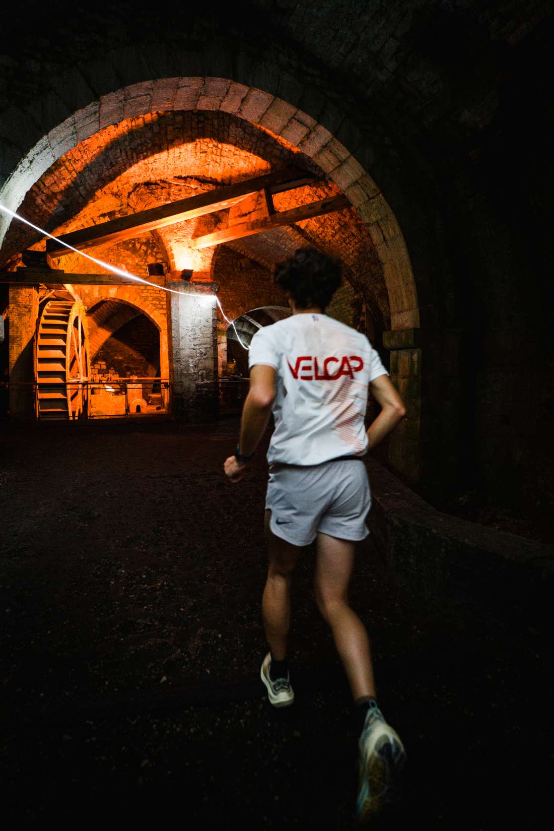 Coureur s'élançant vers une arche éclairée en orange